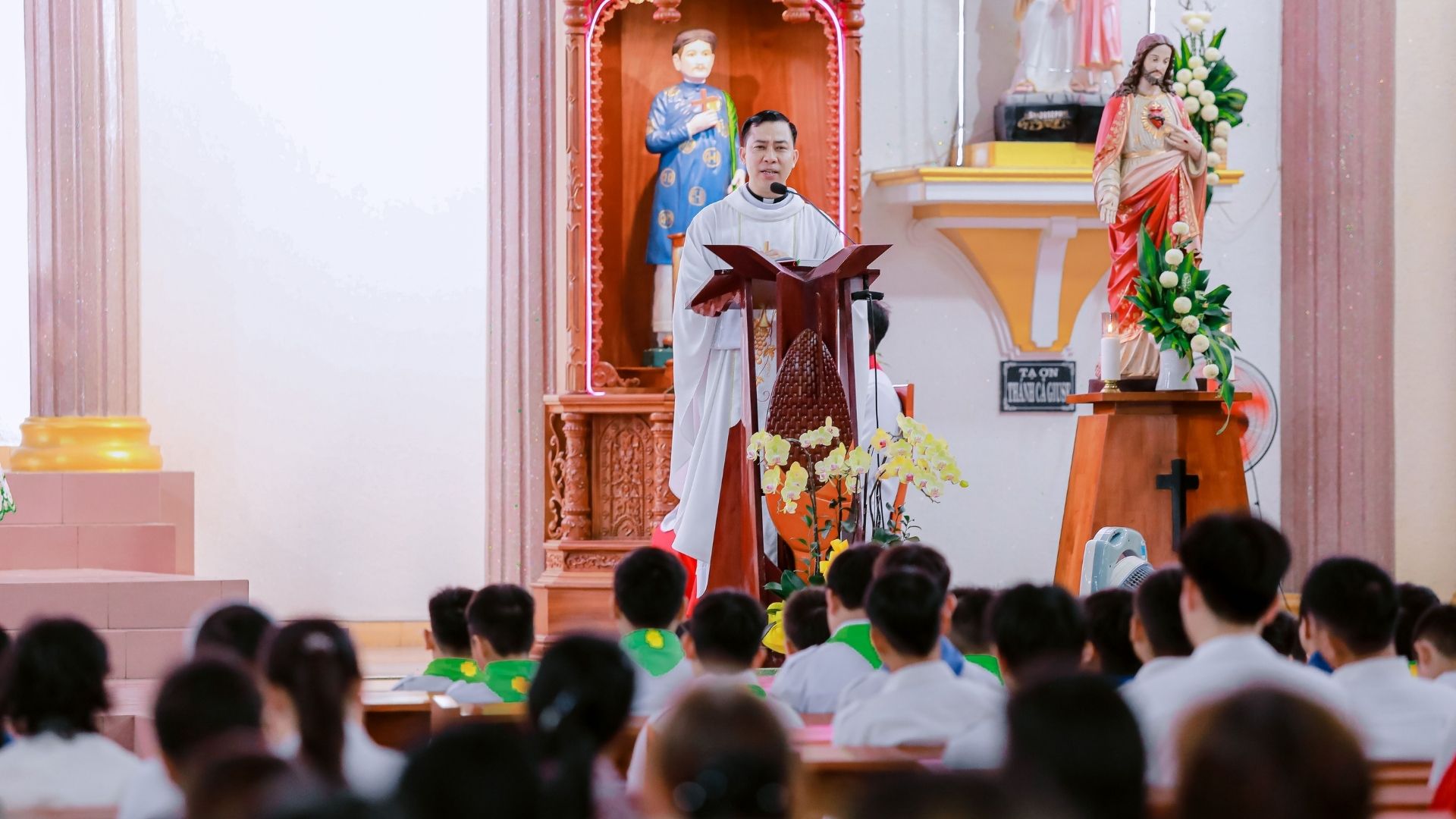 Pastor speaking into a microphone from the sanctuary pulpit during a live Sunday sermon
